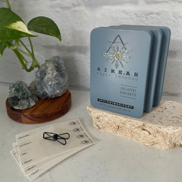 Island Nights Paper Incense in blue tin with 48 natural strips. Infused with a tropical blend of coconut, orange, and earthy tones. Clean-burning and ideal for meditation and intention setting.